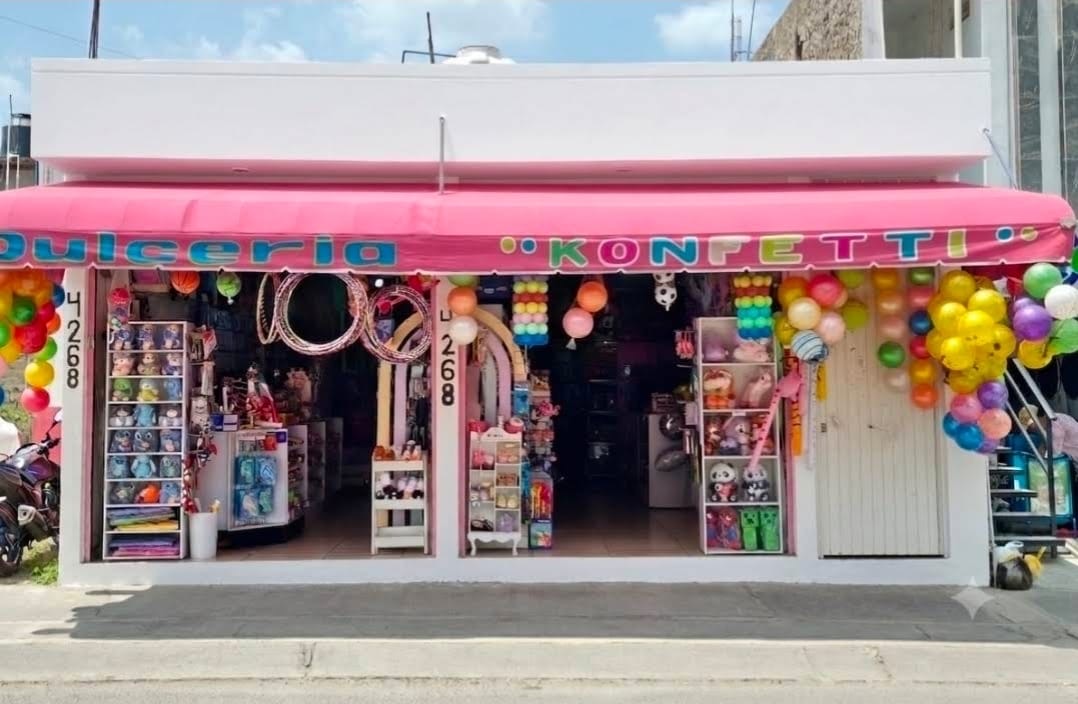 Fachada de Dulcería Konfetti, con toldo rosa y globos de colores